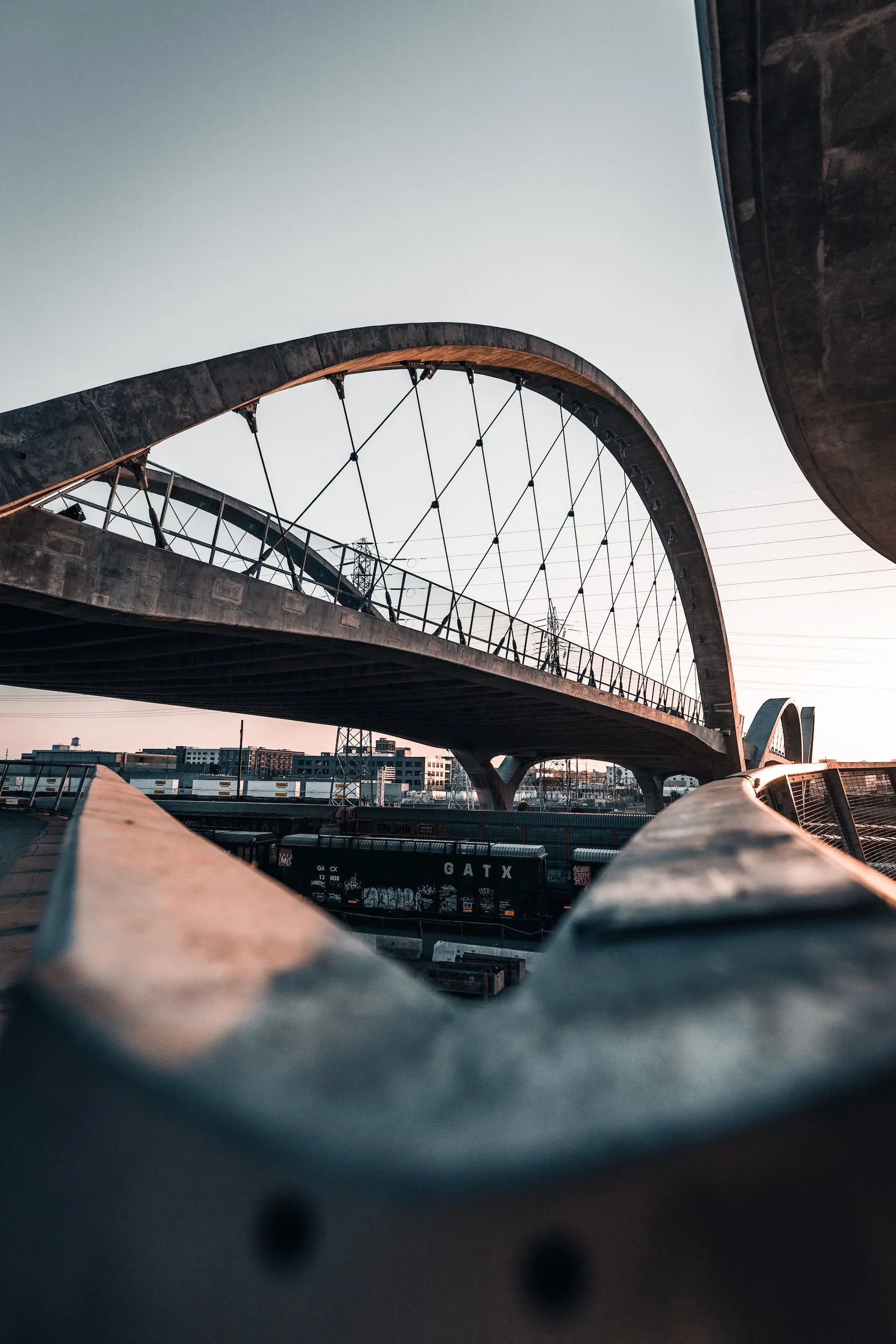 Photo of an architecturally designed bridge with the city skyline behind it